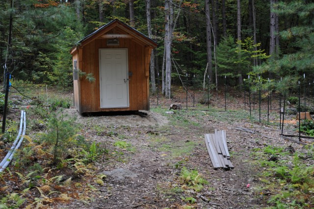 [The small shed is in the middle of the experimental gap, and its 200-amp electrical service provides power to dataloggers and controllers for 9 more plant chambers.]