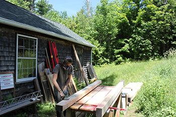 [Sanding some milled timber found in the woodshop garage so that it is easier to paint.]